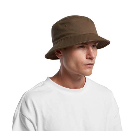 A brown bucket hat with a wide brim, worn by a man in a plain white t-shirt. The hat features ventilation holes.
