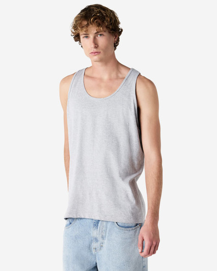 A unisex fine jersey tank in grey, featuring a logo, displayed by a model wearing casual jeans.