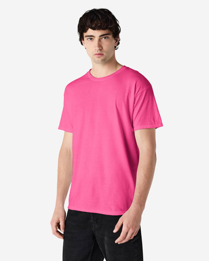 A pink Gildan Heavy Cotton Adult T-Shirt with a crew neck and short sleeves, displayed on a model.