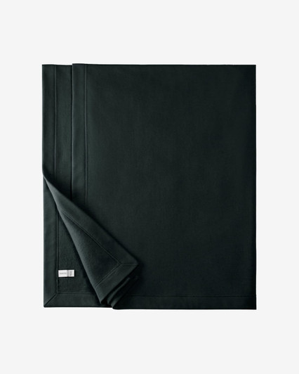 A dark green stadium blanket made from a heavy blend material with a folded edge and a logo tag.