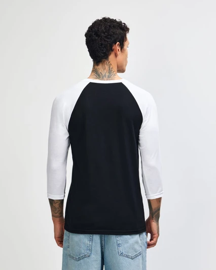 A black and white unisex raglan T-shirt featuring three-quarter sleeves and a logo on the back.