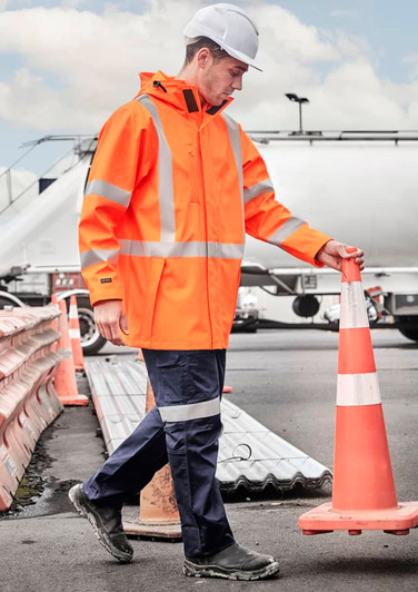 A heavy duty waterproof jacket in bright orange with reflective stripes, worn by a person in a construction environment.