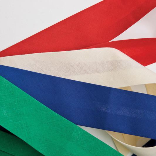 A collection of ribbon strips in red, white, blue, green, and cream laid out on a white background.