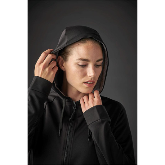 A black women's hoodie with a zip front and a hood, featuring a person adjusting the hood. It has a simple design.