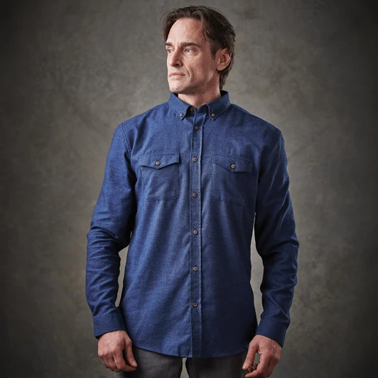 A blue button-up shirt with two chest pockets and a collar, featuring a logo on the front.