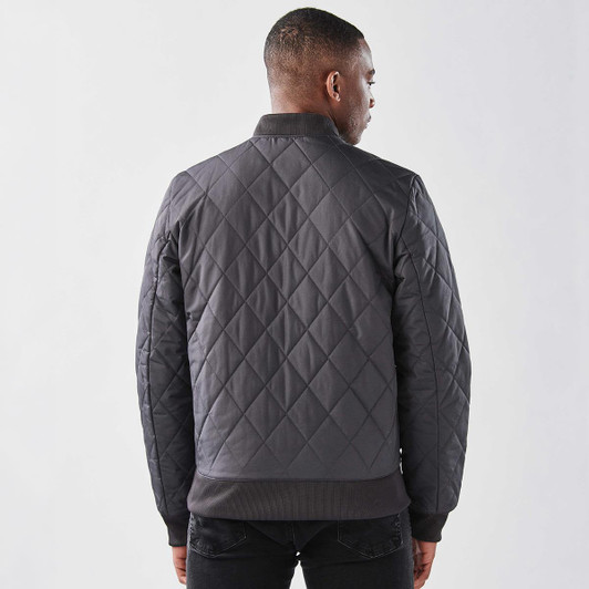 A men's thermal jacket in dark grey with a quilted design and ribbed cuffs. It features a branding logo.