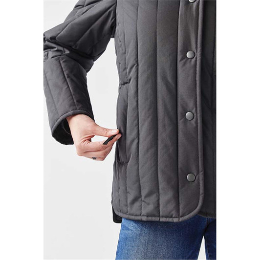 A fitted women's thermal jacket in dark grey, featuring a quilted design and side pockets.