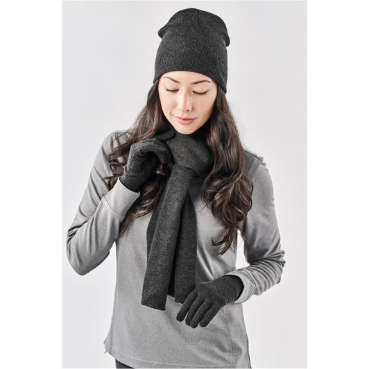 A woman wearing a dark grey knit beanie, matching scarf, and gloves, styled in a grey top.