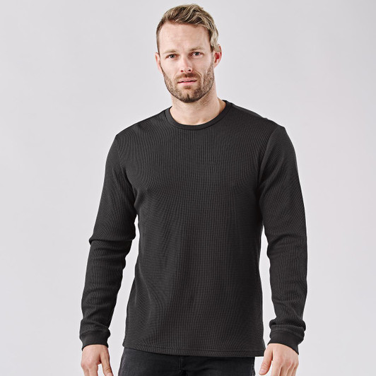 A black long-sleeve crew neck shirt on a model, featuring a simple design and a logo.