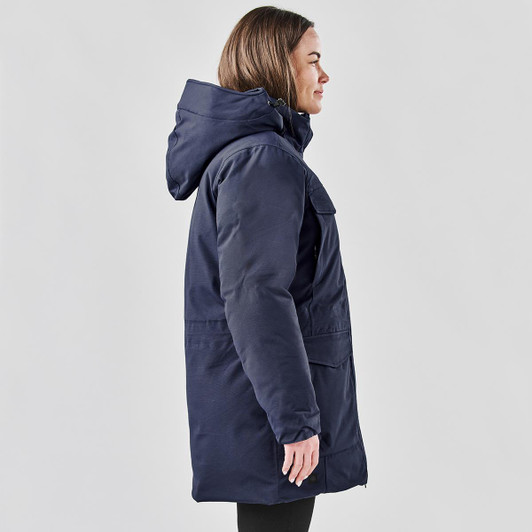 A navy blue Women's Denali Parka jacket featuring a hood and side pockets, displayed on a model.