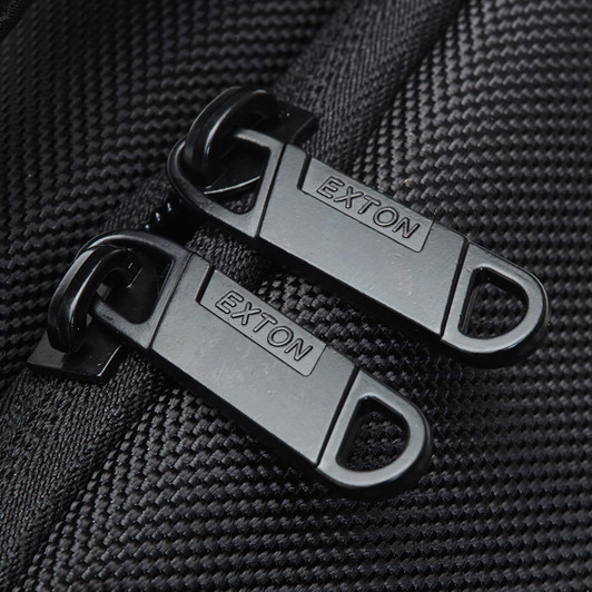 Close-up of black zippers with a branding logo on a textured fabric, part of the Exton Laptop Backpack.