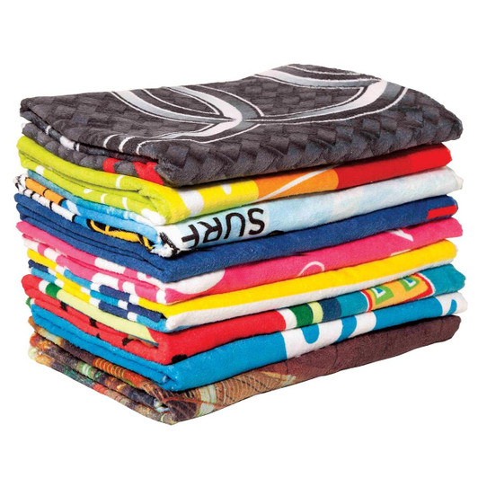 A stack of colourful custom sublimation beach towels in various bright patterns and designs.