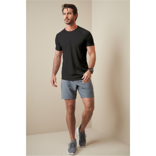 A man wearing a black t-shirt and grey shorts, walking against a neutral background. The t-shirt has a logo.