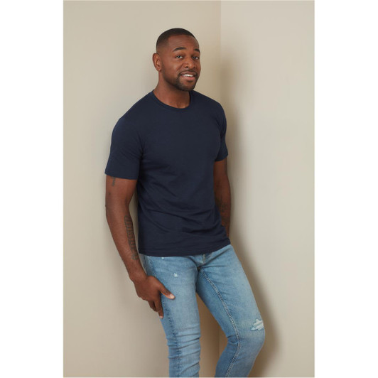 A fitted navy blue T-shirt displayed on a model, paired with light blue jeans, against a neutral background.