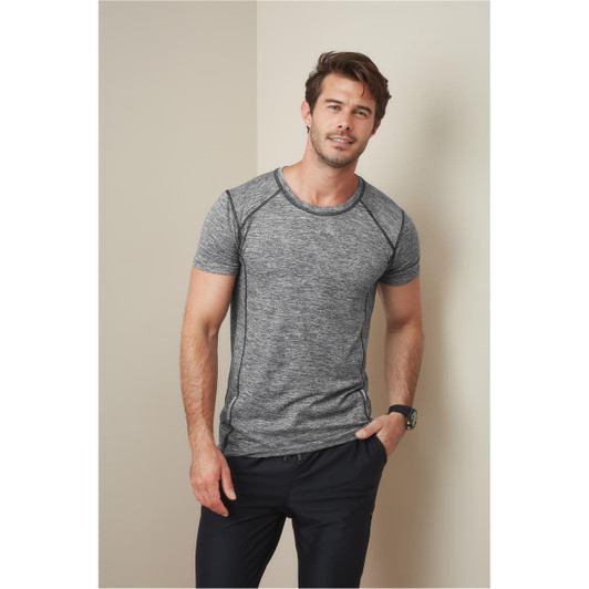 A grey marled men's T-shirt with contrasting seams, featuring a logo on the chest, paired with black trousers.