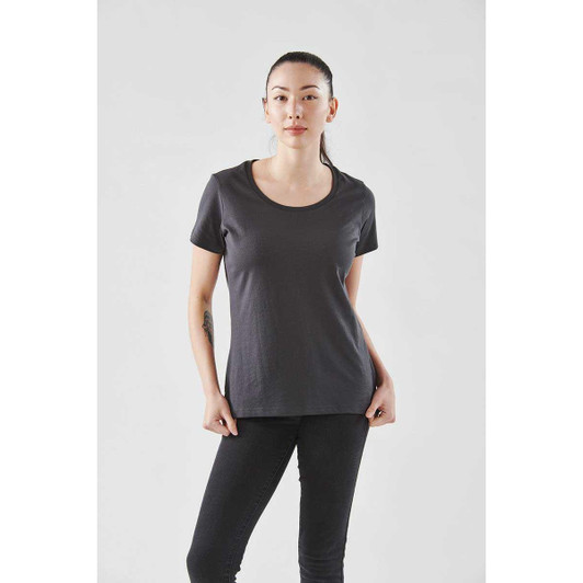 A woman wearing a dark grey short sleeve tee with a round neckline against a plain background.