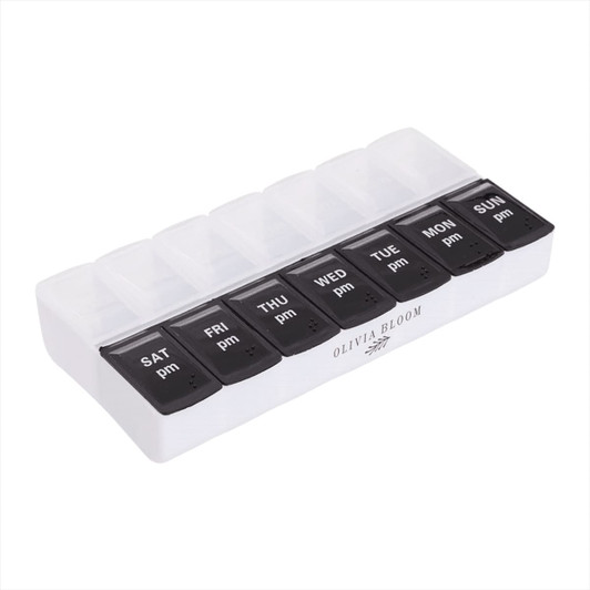 A white and black AM/PM pill case with compartments for each day of the week. Features a logo on the base.