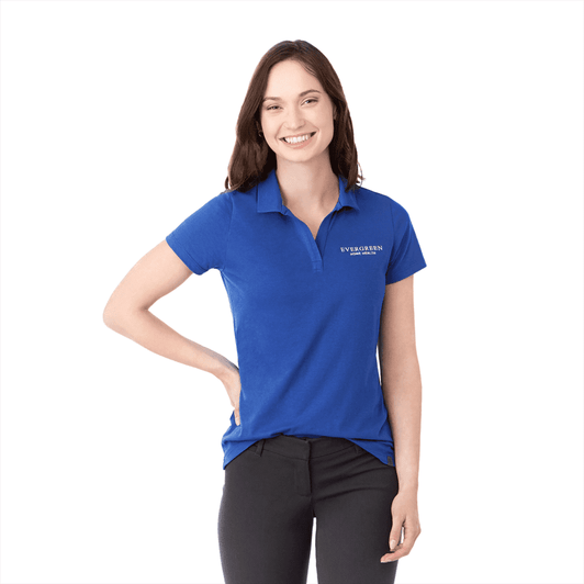 A woman wearing a blue short sleeve polo shirt with a logo on the left chest area.