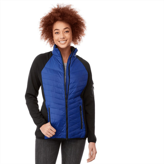 A woman wearing a blue and black insulated jacket, featuring a zip front and side pockets, with a stylish design.