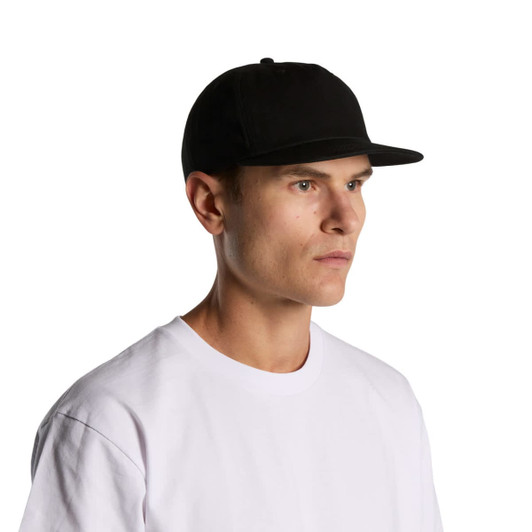 A black cotton cap with a flat brim, worn by a person in a white T-shirt, featuring a logo.