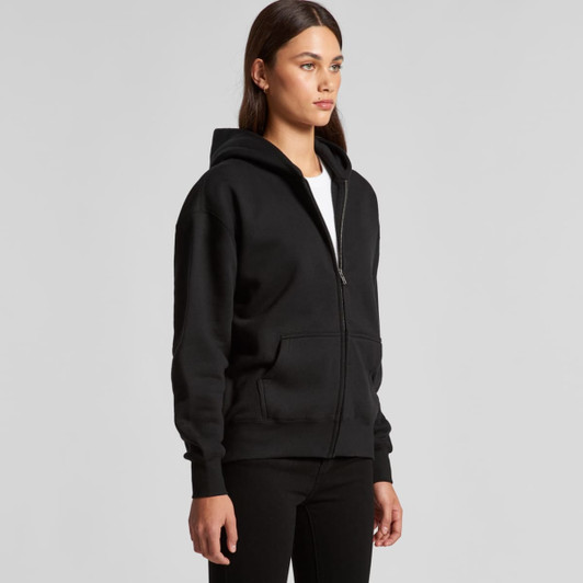A black zip-up hoodie worn by a model, featuring a hood and front pockets. The hoodie has a logo.