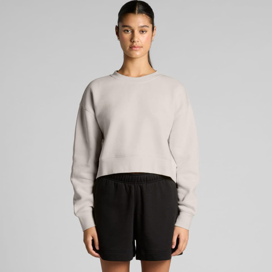 A light grey cropped jumper with a relaxed fit, paired with black shorts, featuring a branding logo.