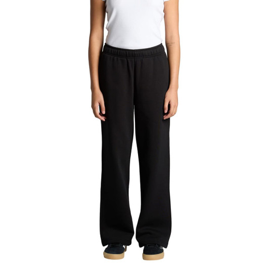 Cuffless track pants in black, featuring a relaxed fit and an elastic waistband. The model stands with hands at sides.