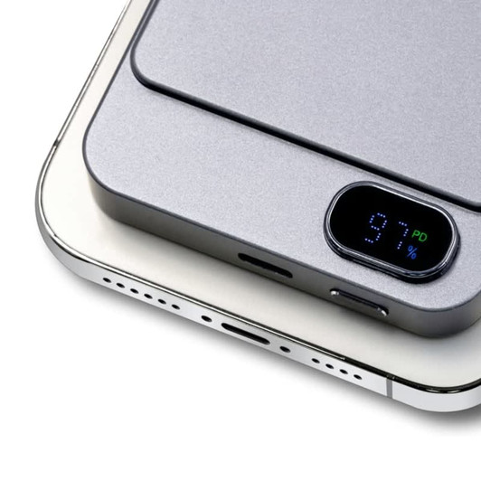 A grey power bank with a digital display showing battery percentage, designed for wireless charging.