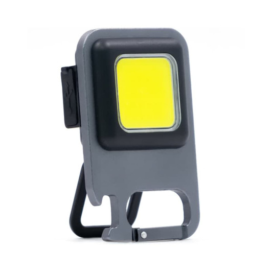 A grey COB LED multi-tool with a square light, featuring a built-in stand and keyring attachment.