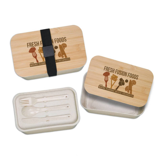 A bamboo lunch box with a strap, featuring a removable inner container and utensils in cream color. It has a logo print.