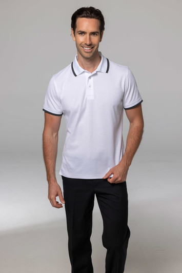 A smiling man wearing a white polo shirt with dark collar and sleeve trims, paired with black trousers.
