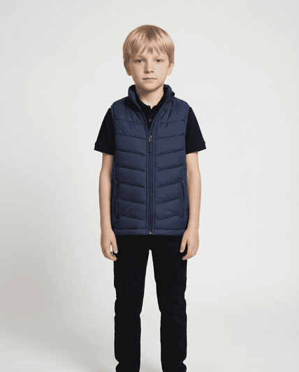 A navy blue puffy vest designed for kids, worn by a child standing in front of a plain background.