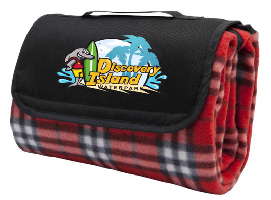 A red check picnic rug folded with a black carrying strap and featuring a logo on the front.