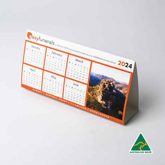 A desk calendar for 2024 with a scenic image, featuring an orange and white design, and a logo.