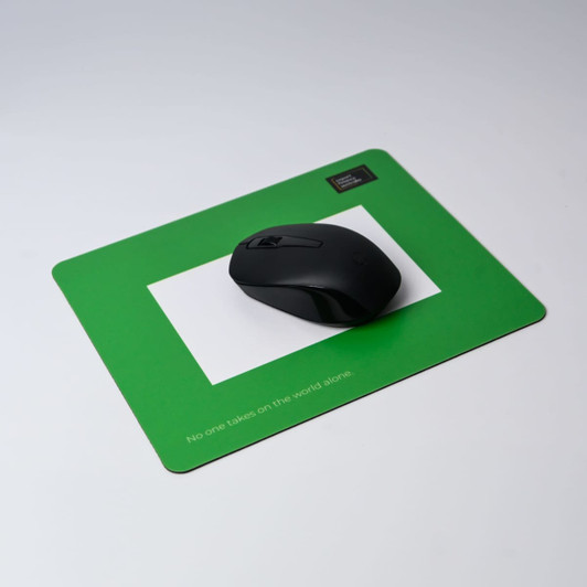 A green photo frame mouse mat featuring a black computer mouse on a smooth surface.