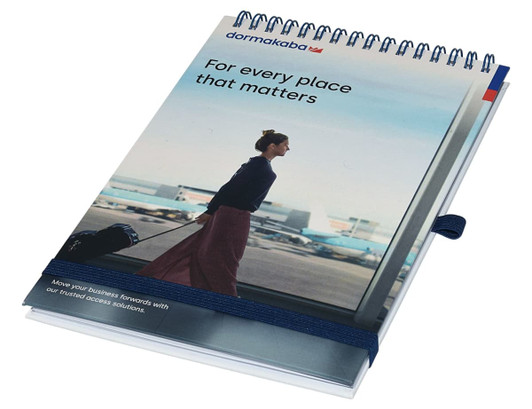 A top-bound A5 notebook with a spiral binding, featuring a blue and white cover design and a logo.