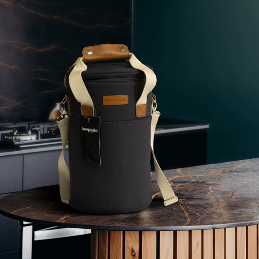 A drink bottle cooler bag in black with a tan handle and adjustable strap, featuring a logo.