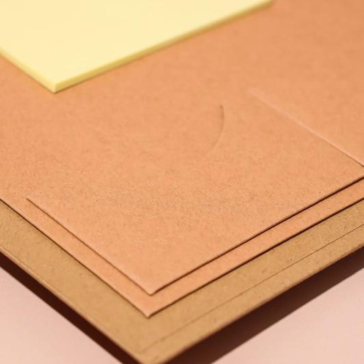 A brown A4 padfolio with a pocket and a sticky note in yellow, featuring a subtle logo design.