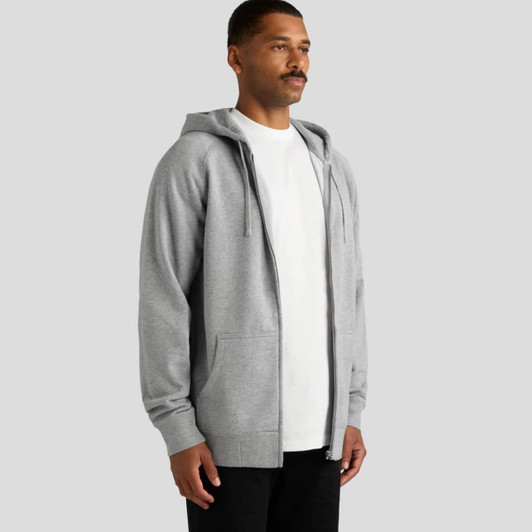 A grey zip-up hoodie with a front pocket, worn by a man. The garment has a hood and a relaxed fit.