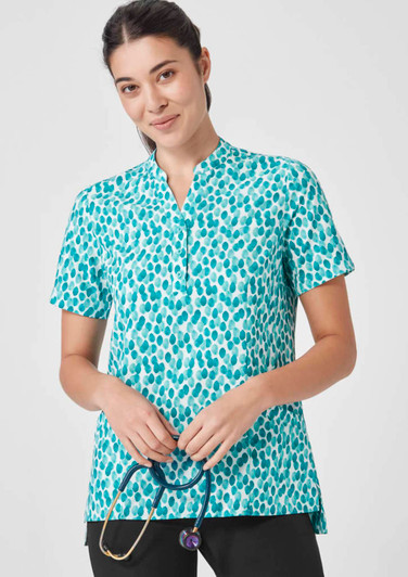 A teal and white patterned tunic top with a stand-up collar, featuring a logo on the chest.