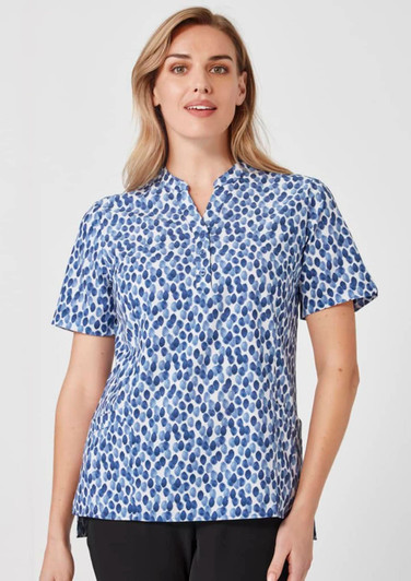 A women's tunic in a blue and white stardust print with short sleeves and a collar, featuring a logo.