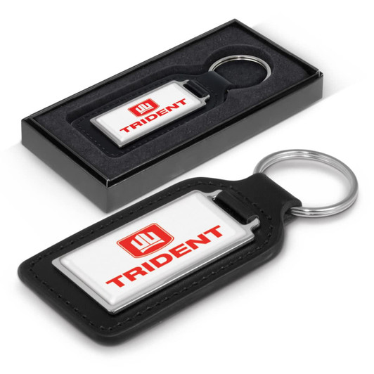 A black leather rectangle key ring with a silver keychain, presented in a black gift box. It features a logo.