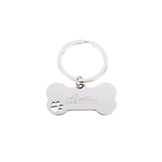 A silver keytag shaped like a dog bone with a small paw print design and a logo.