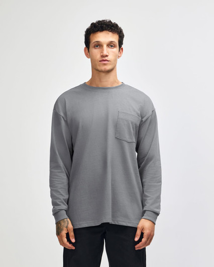 A grey long-sleeve t-shirt with a chest pocket, featuring a logo on the label.