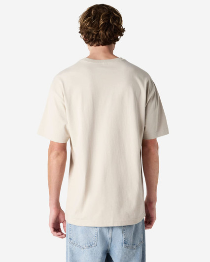 A light beige, unisex heavyweight t-shirt featuring a plain back design. It has a logo on the garment.
