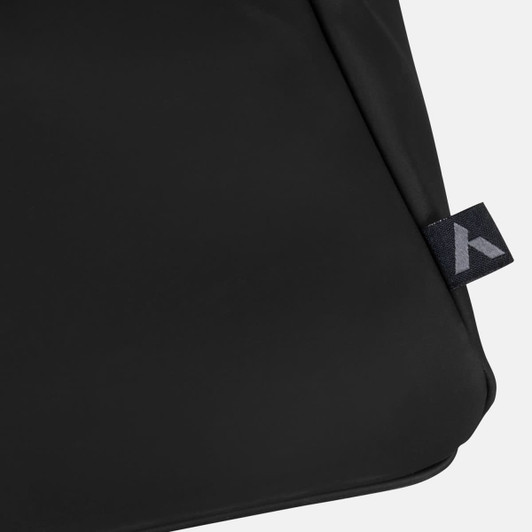 A black soft-touch duffle bag featuring a small branded tag on the side.