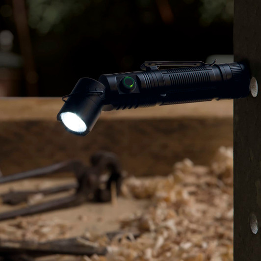 A black FlexLight Torch is mounted on a wooden surface, emitting a bright light. It features a clip and a logo.