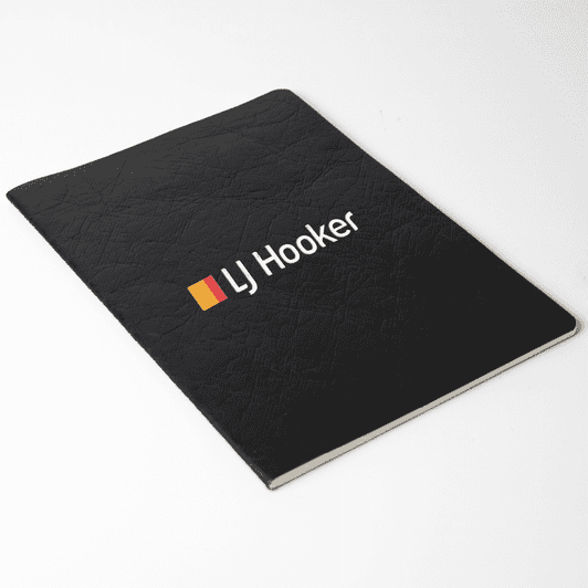 A black Velour DuPont A5 notebook with a textured cover and a logo on the front.