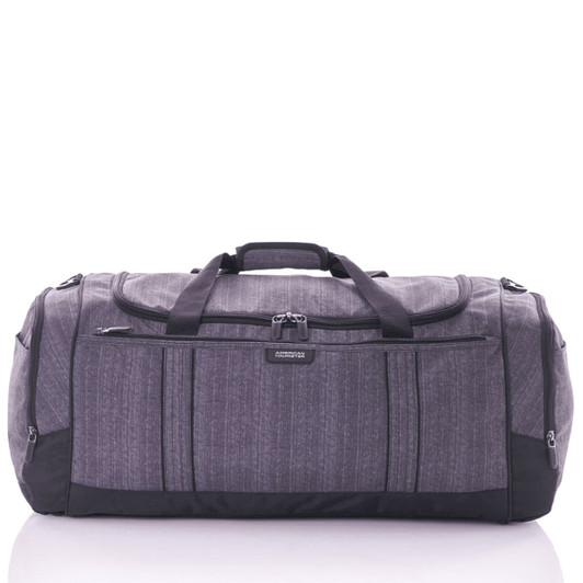 A grey duffle bag with multiple zippered pockets and black accents, featuring sturdy handles and a logo.