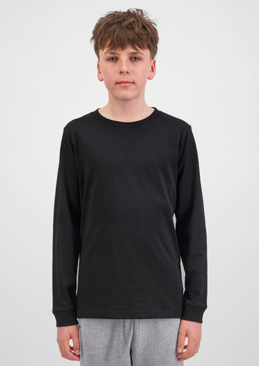 A youth long sleeve tee in black, featuring a simple design and long sleeves. The model stands against a plain background.